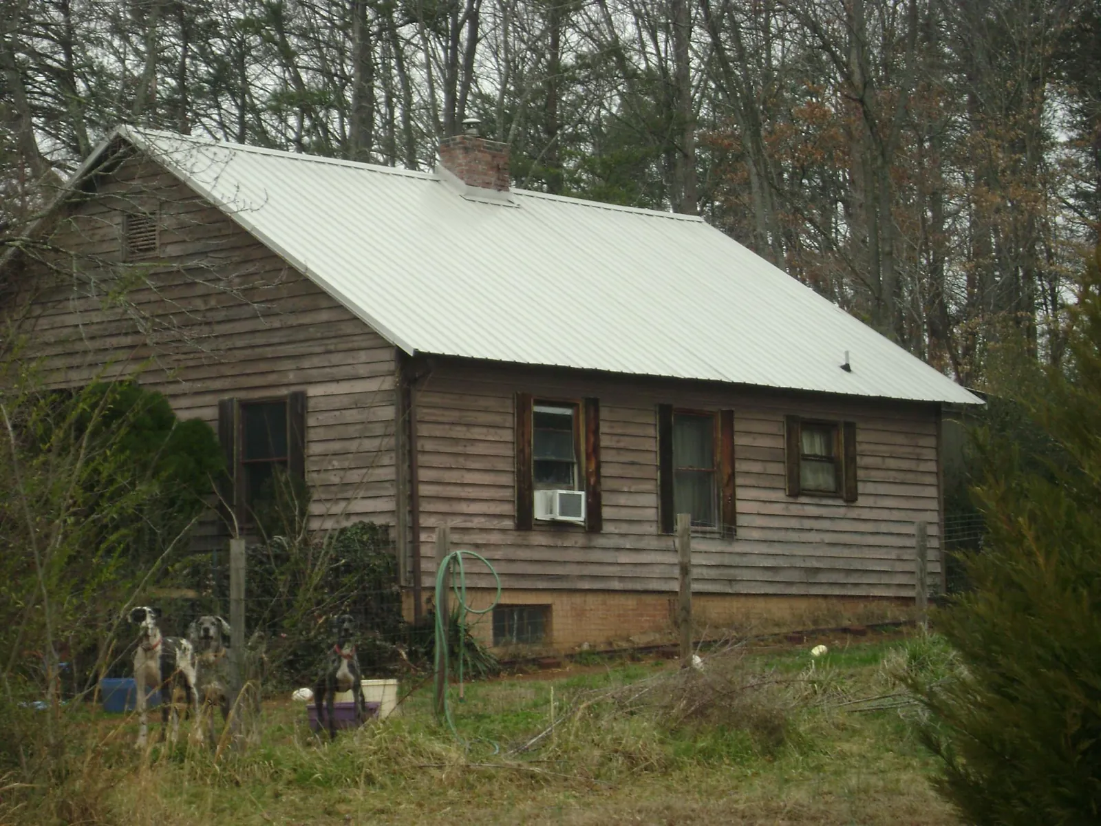 White metal roof on an old wood sided farmhouse, from a Metal Roof Installation job in Milligan